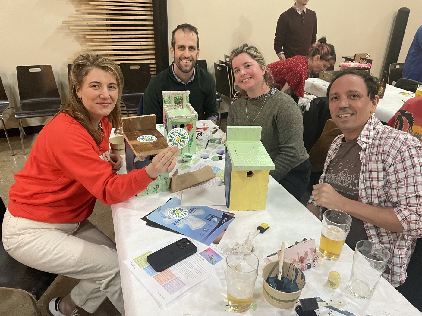 Guests crafting birdhouses around a table during a Checkerspot event