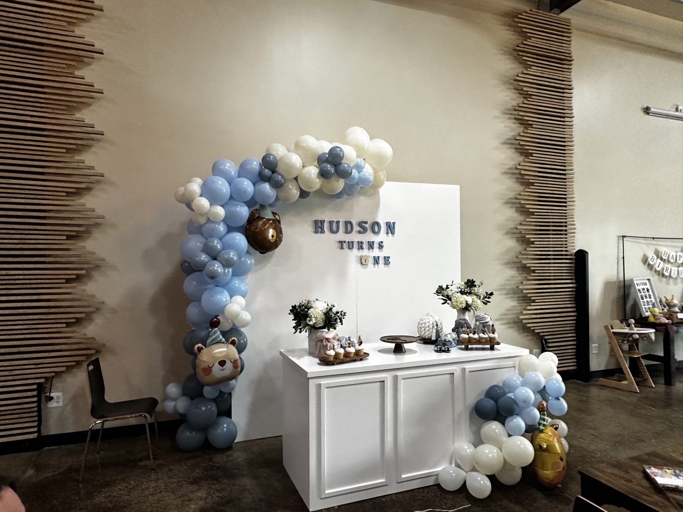 A balloon arch and dessert table set up for a first-birthday party