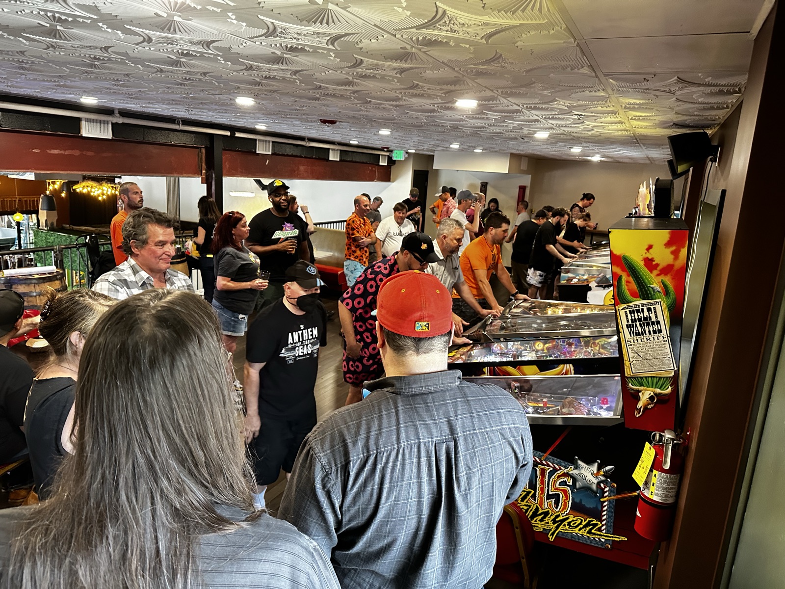 A packed pinball tournament filling the Checkerspot mezzanine